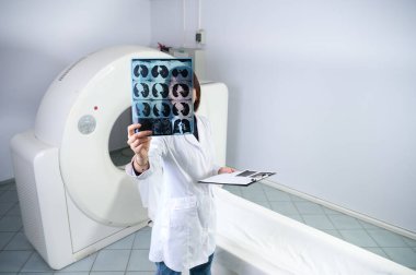 Genç bayan radyologlar tomografi odasında kalıyorlar. Klinikte çalışıyorum. Güzel doktor röntgen, röntgen, tomografi ve MRI 'ya bakıyor. Üniformalı doktor.