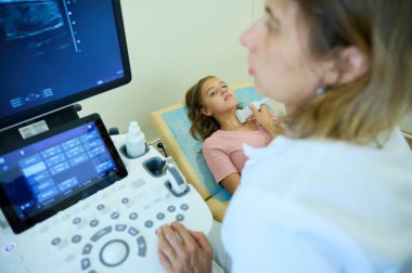 Doktorun çocuk için tiroit sonogramı yapmasına yakın çekim. Pediatrik ultrason taraması. Çocuk ultrasonu. Pediyatrist boynu tarıyor. Lenf düğümlerinin ultrason incelemesi. Çocukluk hastalıkları