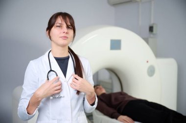 Tarama odasında hastası olan bir kadın radyolog. Tomografi odasında sevimli bir doktor. Radyolog, bilgisayarlı tomografi odasında bir kadın hasta ile birlikte. Modern klinik. Radyoloji Bölümü.