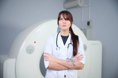 Genç bayan radyologlar tomografi odasında kalıyorlar. Klinikte çalışıyorum. Güzel doktor röntgen, röntgen, tomografi ve MRI 'ya bakıyor. Üniformalı doktor.