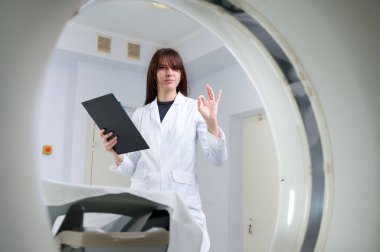 Genç bayan radyologlar tomografi odasında kalıyorlar. Klinikte çalışıyorum. Güzel doktor röntgen, röntgen, tomografi ve MRI 'ya bakıyor. Üniformalı doktor.