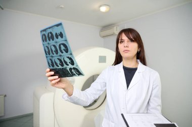 Genç bayan radyologlar tomografi odasında kalıyorlar. Klinikte çalışıyorum. Güzel doktor röntgen, röntgen, tomografi ve MRI 'ya bakıyor. Üniformalı doktor.