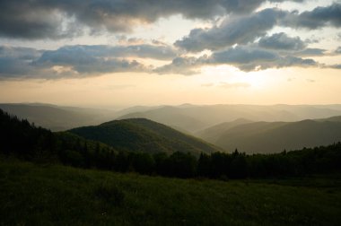 Güneşin doğuşundaki güzel sabah manzarası. Bulutlu gökyüzünde rengarenk gün batımıyla inanılmaz bir dağ manzarası, doğal arka plan seyahati. Göz kamaştırıcı sabah dağı.