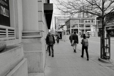 Şehirdeki bir caddenin siyah beyaz fotoğrafı.