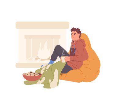 Rahat genç adam çizgi film karakteri sıcak çay içip patlamış mısır yiyor şöminenin yanında oturmuş beyaz arka planda izole edilmiş sıcak sonbahar dönemi vektör ilüstrasyonunun tadını çıkarıyor. Kapalı etkinlik