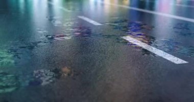 Empty road and raindrops. Moving through the wet road asphalt at night city
