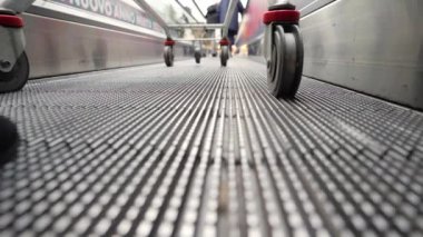 Markette alışveriş arabasıyla yürüyen yolda ya da otoyolda yürüyen genç bir bayan. Düşük açı görünümü