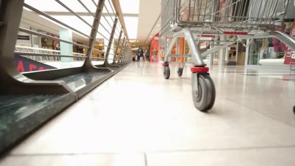 购物车车轮 低角度视图 超级市场上有购物车的年轻妇女 — 图库视频影像