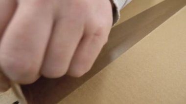Paket açılıyor, yukarıdan görünüyor, yakın plan. Posta sevkiyatı veya kurye teslimatı kavramı