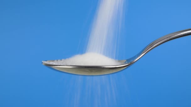 Beyaz Şeker Mavi Arkaplanda Granüle Şeker Dolu Kaşık — Stok video