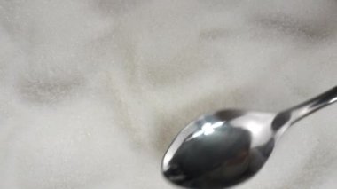 Granüle şeker, yukarıdan görüş. Kaşık beyaz şeker toplar