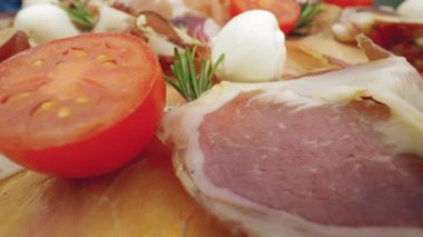 Domuz pastırması dilimleri, jambonlu jambon. Mozarella ve domatesli çiğ jamonu kapat.