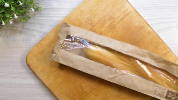 Распаковывать Свежий Багет Доске Французский Хлеб Бумажно Пластиковой Упаковке Вид — стоковое видео