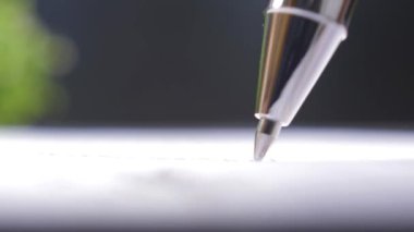 Tükenmez kalem bir sayfa kağıda yazıyor, aşırı yakın plan görünüm