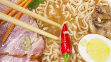 Geleneksel Ramen çorbası. Yemek çubuklarıyla çorba içmek, tepeden manzara.