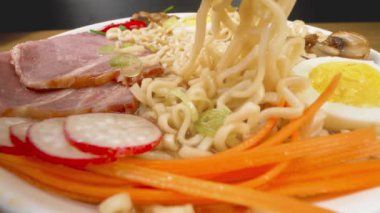 Ramen, geleneksel Japon çorbası. Yemek çubuklarıyla çorba içmek, yakın çekim manzarası.