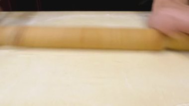 Pasta şefi hamuru ahşap pasta tahtasında karıştırır. Aşçı hamur hazırlar, yakın plan görüntü.