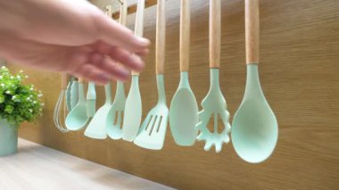 Yemek pişirmek için mutfak aletleri. Mans el bir mutfak kaşığı spatula alır