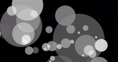 Büyük parçacıklar siyah arkaplanda sorunsuz hareket ediyorlar. Beyaz daireler uzaklaşır