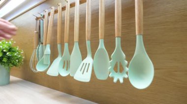 Yemek pişirmek için mutfak aletleri. Mans el bir mutfak maşası alır