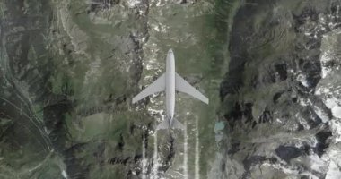 Dağların üzerinden uçan kargo uçağı. Büyük uçaklar yüksek irtifada uçar. Yukarıdan görüntüle