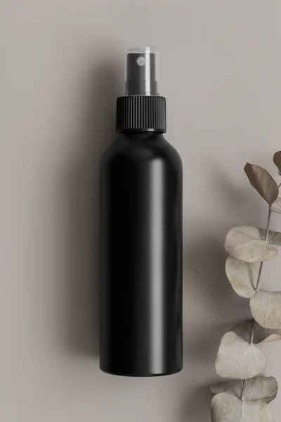 Black cosmetic spray bottle mockup with an eucalyptus on the beige background.