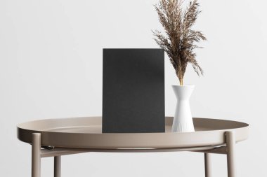 Bej masasında kurumuş çiçek süslemesi olan siyah davetiye modeli. 5x7 oranı, A6, A5 'e benziyor..