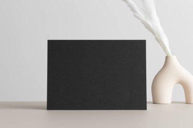 Bej masasında pampa süslemesi olan siyah davetiye modeli. 5x7 oranı, A6, A5 'e benziyor..