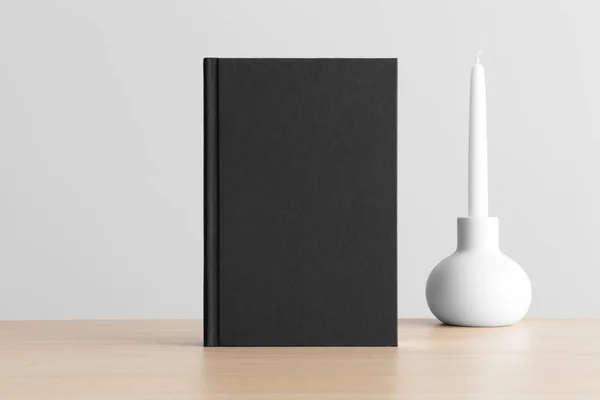 Ahşap Masanın Üzerinde Mum Süslemesi Olan Siyah Kitap Modeli — Stok fotoğraf