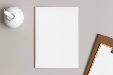 Bej masasında mum ve çalışma alanı aksesuarları olan dergi modeli..