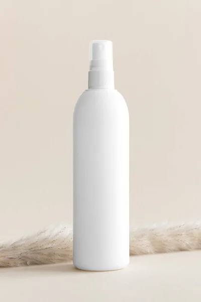 White cosmetic spray bottle mockup on the soft yellow background.