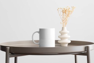 Beyaz kupa modeli ve bej masasının üzerinde Gypthe süslemesi var..