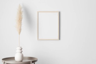 Duvarda ahşap çerçeve, pampa süslemesi var..