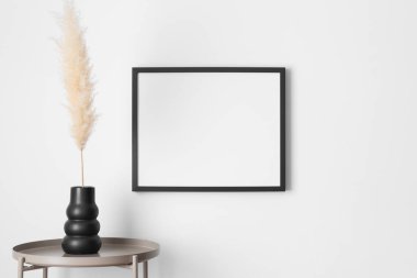 Duvarda pampa desenli siyah çerçeve..