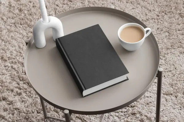 Black book mockup with a candle and a cup of coffee on the beige table.