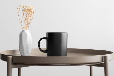 Siyah kupa modeli ve bej masa üzerinde de Gypthe süslemesi..