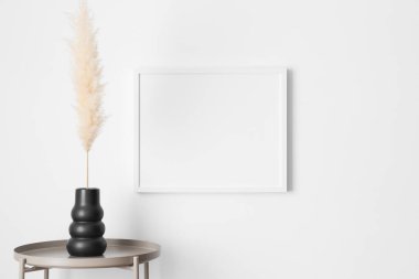 White frame mockup on the wall with a pampas decoration.
