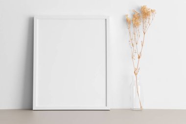 Beyaz çerçeve modeli ve bej masa üzerinde Gypthe dekorasyonu..