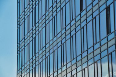blue glass wall of office building mirror reflection cityscape