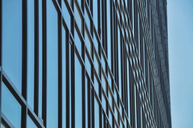 blue glass wall of office building mirror reflection cityscape