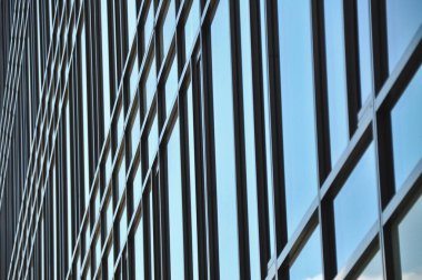 blue glass wall of office building mirror reflection cityscape