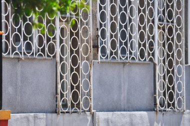 old rusty white fence with circular shapes