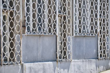 old rusty white fence with circular shapes