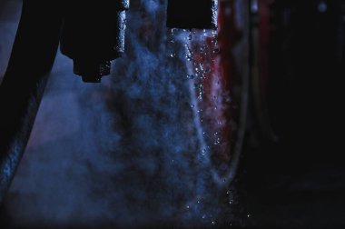 Buhar treninin buharından gelen su, karanlıkta lokomotif, loş fener ışığı.