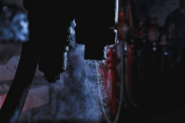 Конденсация воды из пара в паровозе, локомотив в темноте ночью, тусклый свет фонаря