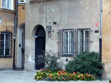 Varşova Polonya 'nın eski kasabasının arka sokağındaki renkli apartmanlar Avrupa' da beyaz pencereler geziyor