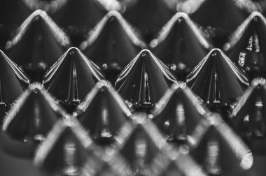 Siyah ve beyaz soyutlamalarla simetrik satırlarda sıralanmış dikiş çivilerinin yakın çekim makrosu