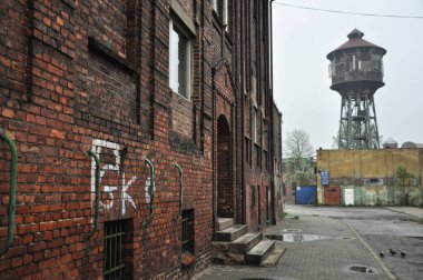 Eski bir tarihi yerleşim yerinin arka planında terk edilmiş eski bir tarihi kule kırmızı pencereler.