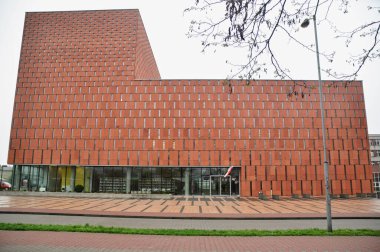 Red brick facade with narrow windows of a modern building, modern architecture clipart