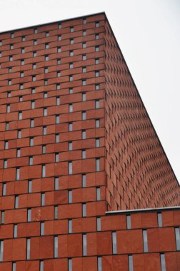 Red brick facade with narrow windows of a modern building, modern architecture clipart